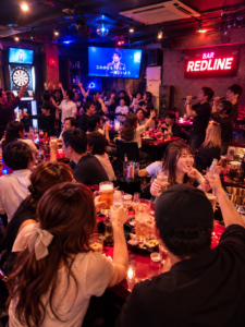 BAR REDLINEでカラオケやダーツ、お酒を楽しむ人々のイメージ